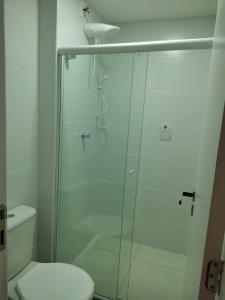 Un baño con ducha de cristal con inodoro. en Apartamento em Ondina, en Salvador 11 fotos más