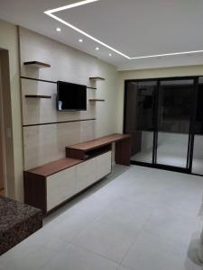 Una sala de estar con un televisor de pantalla plana en una pared. en Apartamento em Ondina, en Salvador
