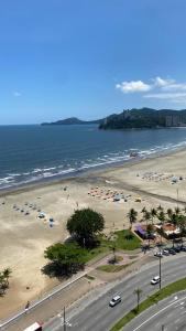 a beach with a bunch of umbrellas and the ocean at Apartamento Frente ao Mar Santos in Santos