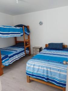 sypialnia z 2 łóżkami piętrowymi w pokoju w obiekcie Casa de playa con piscina en estreno w mieście Camaná