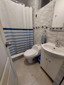 a bathroom with a white toilet and a sink at Casa de playa con piscina en estreno in Camaná