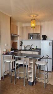 a kitchen with a table and chairs and a refrigerator at Departamento bien ubicado in Concepción