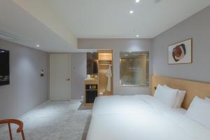 金海にあるAsherah Villa d' aqua Hotelのベッドルーム(大きな白いベッド1台付)、キッチンが備わります。