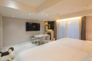 a bedroom with a white bed and a table at Asherah Villa d' aqua Hotel in Gimhae