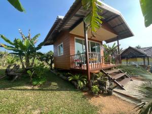 a small house with a porch and a balcony at Rak Suan Homestay รักสวนโฮมสเตย์ in Khao Lak +45 photos
