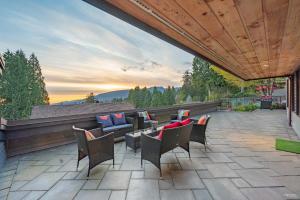 a patio with chairs and a couch and a table at Seymour Private Bedroom, Ensuite Bathroom with Shared Pool, Hot Tub with Views in North Vancouver
