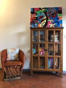 a chair sitting next to a cabinet with a painting at Casa Gecko in Oaxaca City