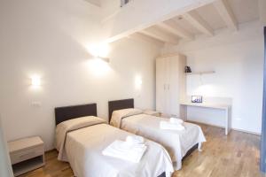 a hotel room with two beds and two night stands at Hotel Arezzo ASC in Arezzo