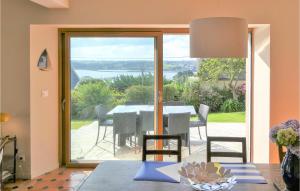 a dining room with a table and a large glass window at Beautiful Home In Perros-guirrec With 4 Bedrooms And Wifi in Perros-Guirec