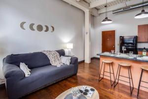 ロチェスターにあるNY Style Centric Loft w/ KingBedの青いソファとキッチンのあるリビングルーム +17枚の写真
