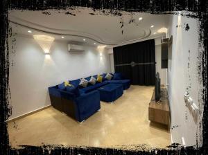 a living room with a blue couch and a television at Standing Tétouan Apparts WIFI&PARKING in Tetouan