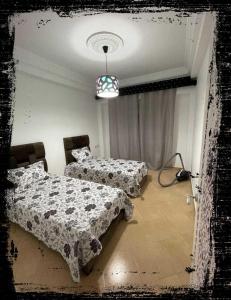 a room with two beds and a lamp in it at Standing Tétouan Apparts WIFI&PARKING in Tétouan