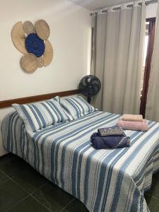 a bedroom with a bed with a blue and white comforter at Le Corsaire in Búzios