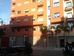 a tall orange building on the side of a street at Khalid in Beni Mellal