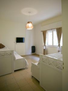 a bedroom with two white beds and a window at La Casa de la Plaza in San Antonio de Areco