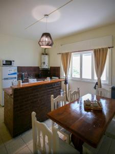 a kitchen and dining room with a wooden table and chairs at La Casa de la Plaza in San Antonio de Areco