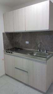 a kitchen with a sink and a stove top oven at Coliving Cali in Cali