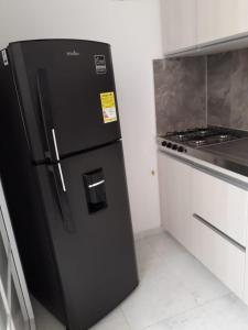 a black refrigerator in a kitchen next to a stove at Coliving Cali in Cali