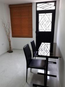 a dining room with a table and two chairs and a window at Coliving Cali in Cali