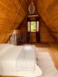 1 dormitorio con 1 cama en una cabaña de madera en Recanto da Vila - Chalé 01, en Governador Celso Ramos