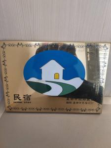 une boîte avec une photo d'une maison sur elle dans l'établissement Mountain Homestay 6-8人包棟民宿, à Xinhua