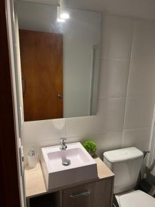 a bathroom with a sink and a toilet and a mirror at Apart del Este 5 in Paysandú +11 photos