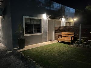 a bench sitting outside of a house at night at Apart del Este 5 in Paysandú