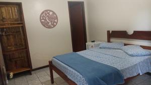 a bedroom with a bed with a blue comforter at Pousada Exuberante in Abraão