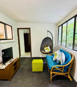 uma sala de estar com um sofá azul e uma televisão em Botanica House Kuranda em Kuranda