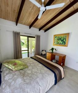 1 dormitorio con cama, escritorio y ventana en Botanica House Kuranda en Kuranda