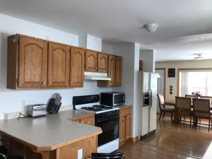 a kitchen with wooden cabinets and a counter top at Lakeside Luxury 4 bedrooms 2 bath sleeps 10 with Gazebo and Firepit in Presque Isle