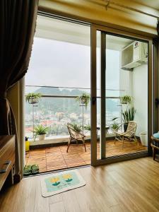 una sala de estar con una puerta corredera de cristal con vistas en Mon Sapphire Homestay * View Sea and Poem Mountain en Ha Long