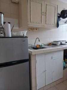 a kitchen with a white refrigerator and a sink at Apartamento centralizado melgar in Melgar
