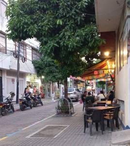a group of people sitting at tables on a city street at Apartamento centralizado melgar in Melgar