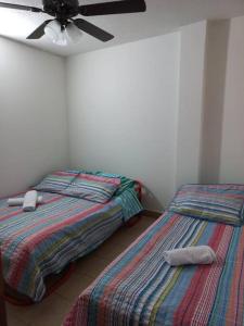 two beds sitting next to each other in a bedroom at Apartamento centralizado melgar in Melgar