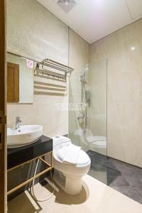 La salle de bains est pourvue de toilettes, d'un lavabo et d'une douche. dans l'établissement KESATRIYAN JOGJA GUEST HOUSE, à Yogyakarta