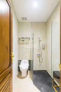 y baño con aseo y cabina de ducha de cristal. en KESATRIYAN JOGJA GUEST HOUSE en Yogyakarta