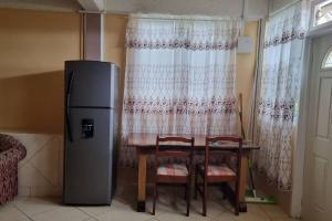 a kitchen with a table and a refrigerator next to a window at Arliebev Apartments in Mahaut