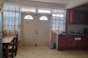 a kitchen with a white door and a sink at Arliebev Apartments in Mahaut