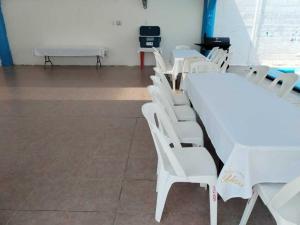 una camera con sedie bianche e tavolo bianco di alberca Blass a Coatzacoalcos