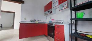 a kitchen with red cabinets and a black stove at Casa Kanté in Tamasopo