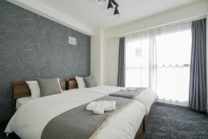 a bedroom with a large bed and a large window at 37MB HOTEL in Sapporo