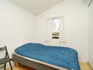 Cama en habitación blanca con ventana en Holiday home Melby IV, en Melby