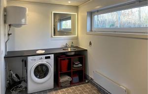 eine Waschküche mit einer Waschmaschine und einem Waschbecken in der Unterkunft Beautiful Home In Asarum With Kitchen in Asarum
