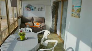 フエンヒロラにあるApartamento en los Boliches , (Fuengirola)の小さなお部屋で、テーブル、椅子、ソファが備わります。