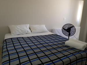 a bedroom with a bed with a fan on it at Jockey Family Chamonix 2 in Vila Velha