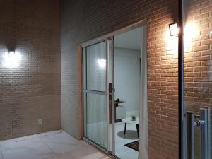 a glass door in a brick wall with a table at Jockey Family Chamonix 2 in Vila Velha