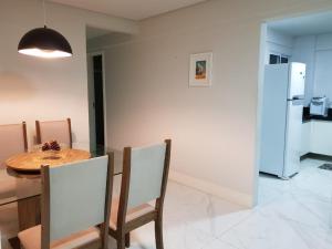 a kitchen and dining room with a table and chairs at Jockey Family Chamonix 2 in Vila Velha