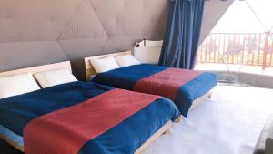 two beds in a room with a window at HIKARI DOME - Vacation STAY 89725v in Teruma