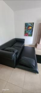 um sofá de couro preto com duas almofadas num quarto em Departamento Planta Alta Ciudad Mendoza em Las Heras